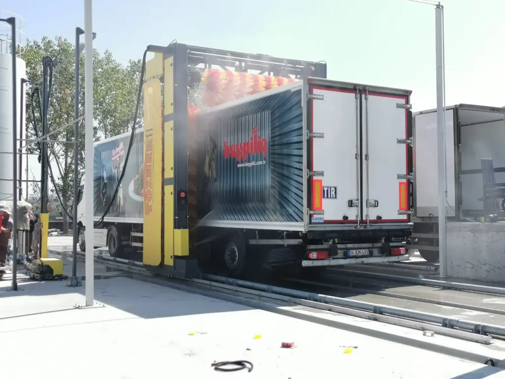 Wash gantry spraying the side of a box trailer on an outdoor wash lane